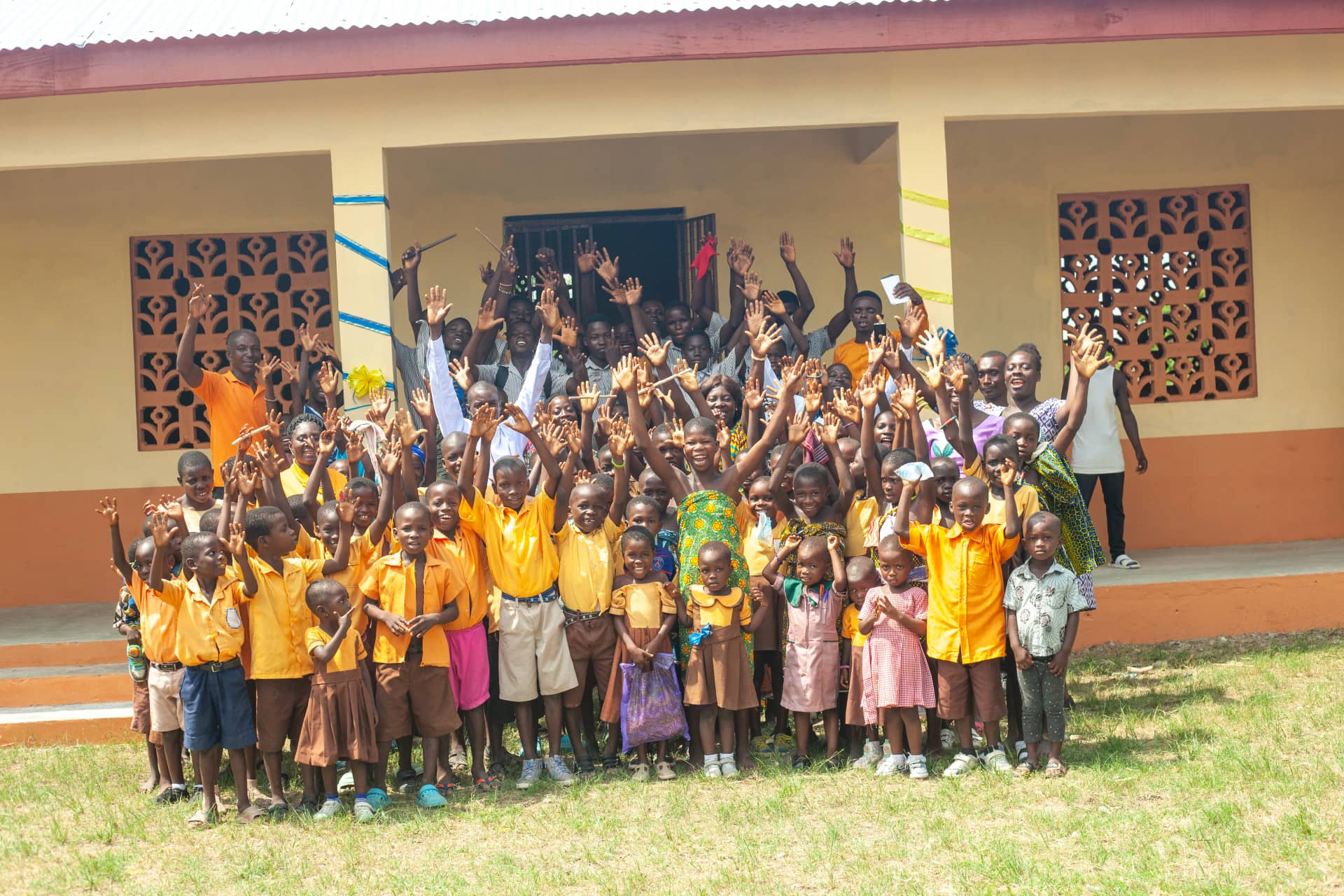 Children in rural Ghana raising their hands